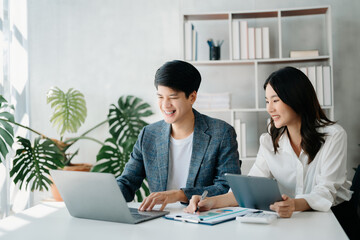 Businesswomen work and discuss their business plans. A Human employee explains and shows her colleague the results paper in modern office..