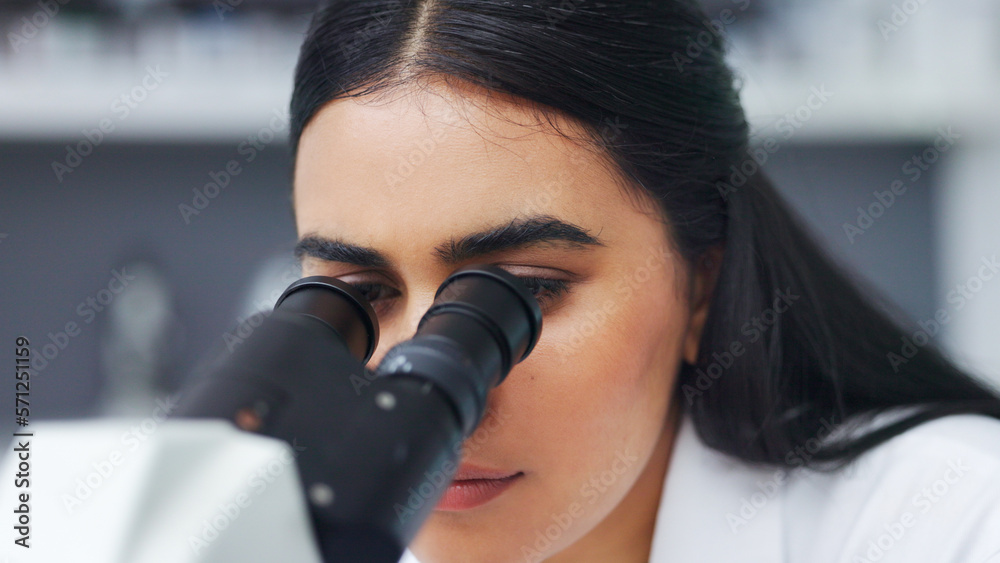 Poster Female scientist using a microscope in a research lab. Young biologist or biotechnology researcher working and analyzing microscopic samples with the latest laboratory tech equipment