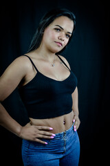Portrait of a young Brazilian woman with her hands on her hips, wearing jeans and a black top