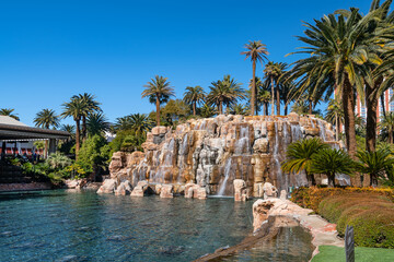 Waterfall and pond with palm trees next to the Mirage Hotel and Casino on the Strip in Las Vegas,...