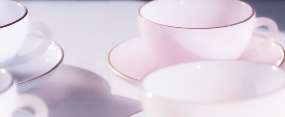 Abstract dreamy soft background of pastel glass teacups and saucers, pale lilac and grey