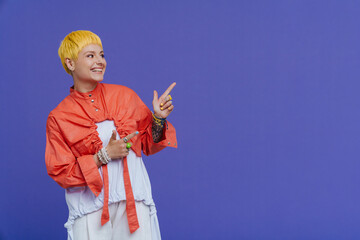 Young beautiful stylish short-haired smiling woman pointing and looking aside