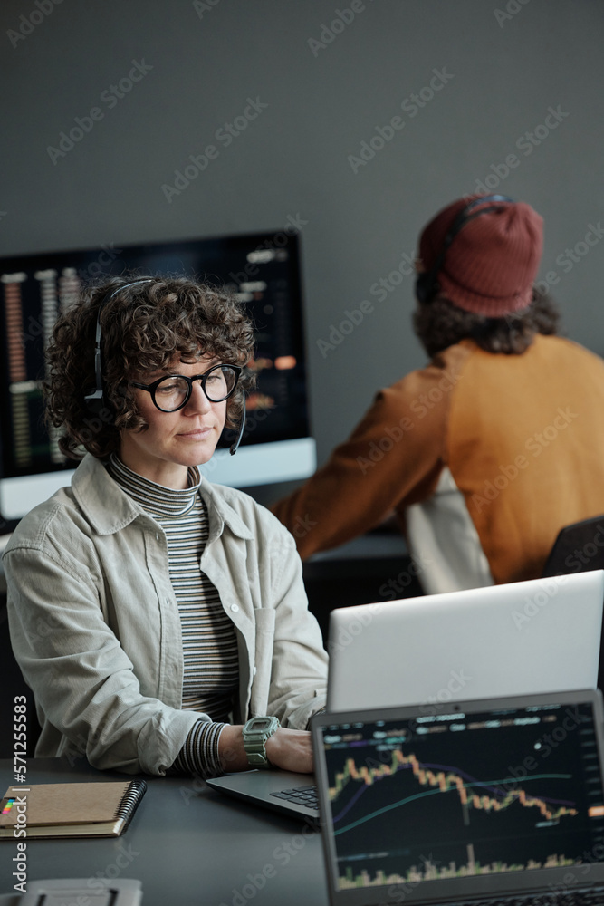 Aufkleber Young serious female operator of call center sitting by desk in front of laptop, working with online data and consulting clients