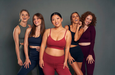 Group of five young women in sports clothes in studio shot