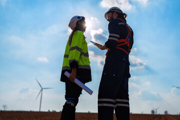 Wind turbine service engineer standing on ground planning for maintenance electricity generator