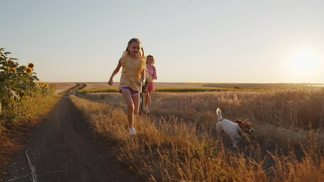 Happy young woman on retro bike smiling girl runs dog Jack Russell Terrier rejoices at something shouting to dad off-screen. Mom daughter walking. Family summer holidays in village. Pet. Life