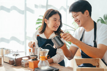 Young Asian couple doing holiday together in the kitchen happily wearing apron. love and valentine concept