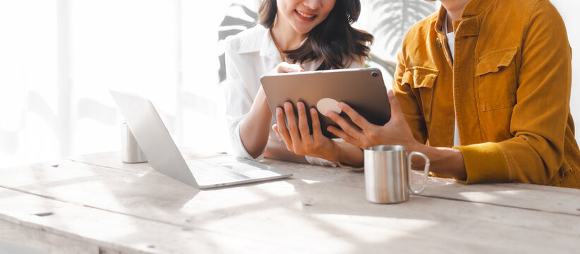 Asian couple husband and wife using laptop and paper bills at home use banking applications sit together at the table A cautious family spouse is confused by high expenses. insurance or rent concept