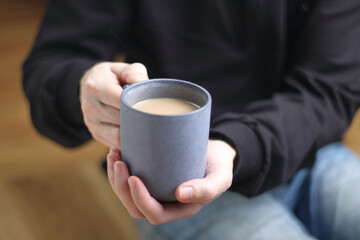 person holds a cup with coffee