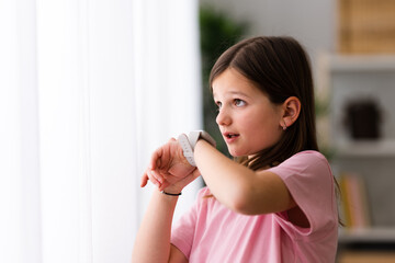 Little girl talking on smartwatch