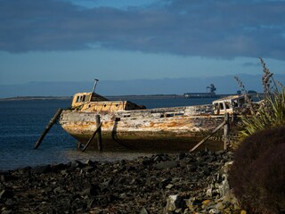 Remains ruins of an old historical capsized tilted fishing boat ship wreck at Greenpoint Ship...