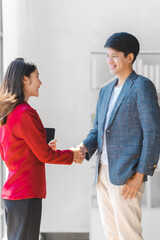 Working together business person with friends asian people in formal business suit red and blue color, bookkeepers receives good news by e-mail. Shaking hands