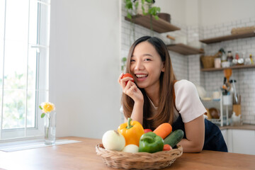 Obraz premium Pretty Asian woman preparing healthy breakfast at home in modern and beautiful kitchen, smiling brightly.