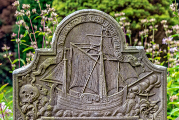 Grabstein mit Segelschiff von einem historischen Seemannsgrab auf dem Friedhof der St. Laurentii Kirche in Süderende auf der Nordseeinsel Föhr