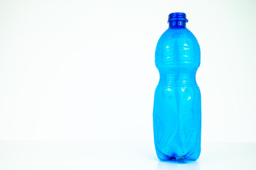 Blue plastic bottle, on a white background. Plastic recycling and eco-sustainability. 
