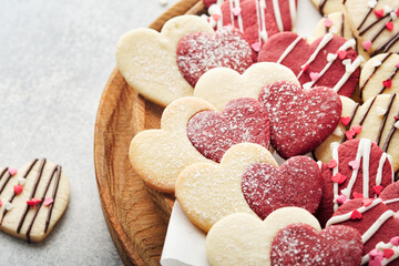 Valentines day cookies. Shortbread cookies inside sweet red heart with chocolate glaze on pink plate on grey background. Mothers day. Womans day. Sweet holidays baking. Valentines day card. Top view.