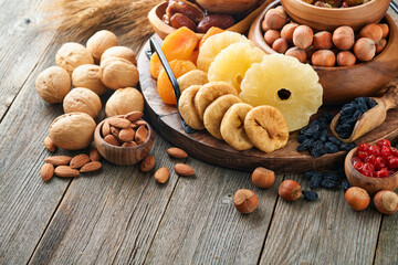 Tu Bishvat celebration concept. Mix of dry fruits and nuts almonds, hazelnuts, walnuts, apricots, prunes, cherries, raisins, dates, apples, figs over wooden table. Jewish holiday, new year of trees.