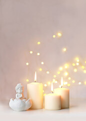 Fototapeta na wymiar little Buddha statue and burning candles on table close up, abstract blurred light background. esoteric spiritual practice, Relax time, harmony, meditation. life balance concept