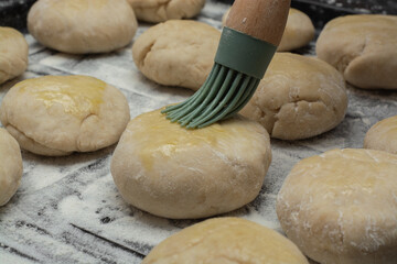 
raw bread dough with flour scattered on a black table