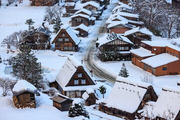 Snow covered A-frame roofs in historic Japanese mountain town in winter - 571275548