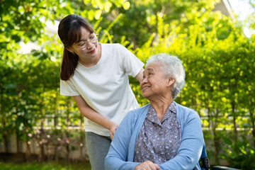 Caregiver help and care Asian elderly woman use walker with strong health while walking at park in happy fresh holiday.