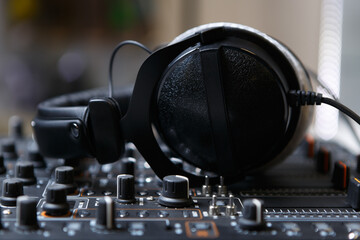 Fototapeta na wymiar DJ headphones on sound mixer. Close up photo of professional headset for disc jockey