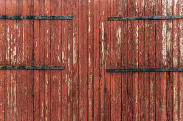Detail of antique wooden door in red tones, with lots of texture and pickled paint.