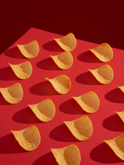 Potato chips on red background with very sharp shadows