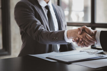 Business investor group holding hands, Two businessmen are agreeing on business together and shaking hands after a successful negotiation. Handshaking is a Western greeting or congratulation.