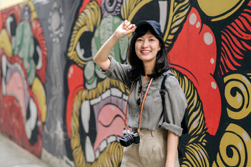 Fototapeta na wymiar Young Asian woman backpack traveler enjoying street cultural local place and smile. Traveler checking out side streets. Journey trip lifestyle