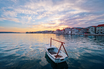 Beautiful sunset landscape. Fishing boat moored on Kastel coast in Dalmatia,Croatia.Old town near...
