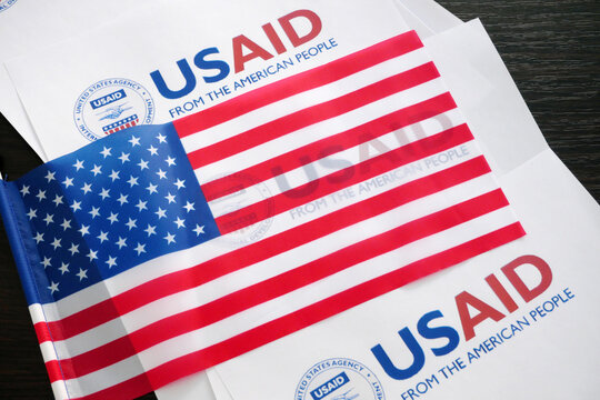 Kiev, Ukraine - 02 12 2023:  USAid logo and US flag, USAid is USA agency for international development - assistance abroad, closeup