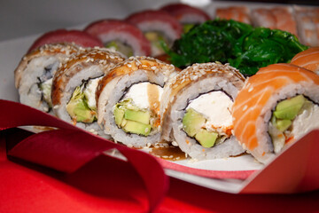 salmon tuna chuka shrimp eel sushi rolls set with red ribbon