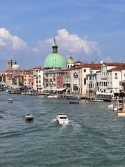 Main canal in Venice with cathedral, buildings and moving boats