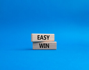 Easy win symbol. Wooden blocks with words 'Easy win'. Beautiful blue background. Business and 'Easy win' concept. Copy space.