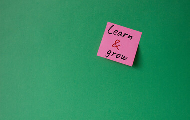 Learn and grow symbol. Concept words Learn and grow on pink steaky note. Beautiful green background. Business and Learn and grow concept. Copy space.