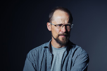 Worried middle age man in shirt frowning eyebrows looking to the side