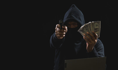 Hacker spy man hands wearing a black shirt, sitting on a chair and a table, is a thief, holding...