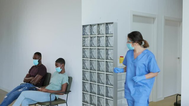 Health worker calls patients in turn for vaccination.