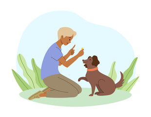 A boy teaches dog how to paw in the outdoors. Pet ownership communicating with puppy.