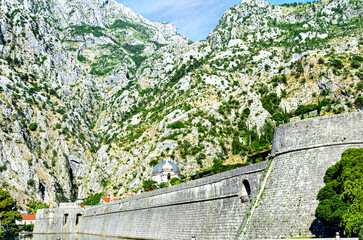 
View of the kampana tower, wall of the ancient fortress of kotor, under the mountains. montenegro.
