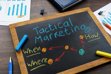 Blackboard with inscription tactical marketing and crayons.