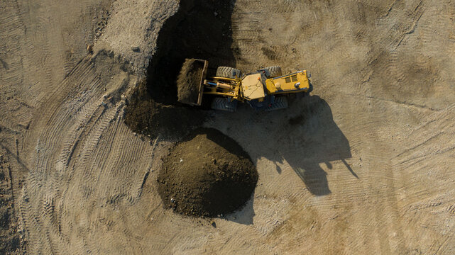 A front end loader machine tipping sand in a quarry