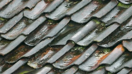 View of raindrops falling on the tiled roof of a simple house in the village - Powered by Adobe