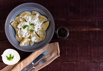 Dumplings with sour cream on a gray plate. Top view.