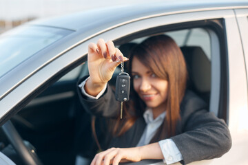 Happy woman driver showing car keys.