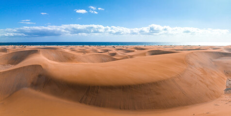 Fototapeta na wymiar Panoramic aerial scene of the Maspalomas Dunes in Playa del Ingles, Maspalomas, Gran Canaria, Spain. Endless desert sands. Magical safari dunes.
