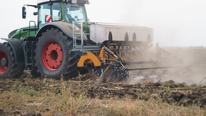 Tractor working in the field. Autumn tillage. Deep ripping with powerful tractor