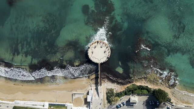 Aerial view of the Rotonda sul Mare, a roundabout pier along the coastline facing the Mediterranean Sea, Avola, Syracuse, Sicily, Italy.
