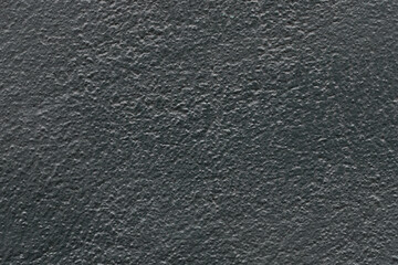 Abstract dark gray painted stone uneven texture, black wall background.